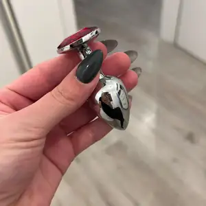 Metalowy koreczek z dupci czerwone oczko