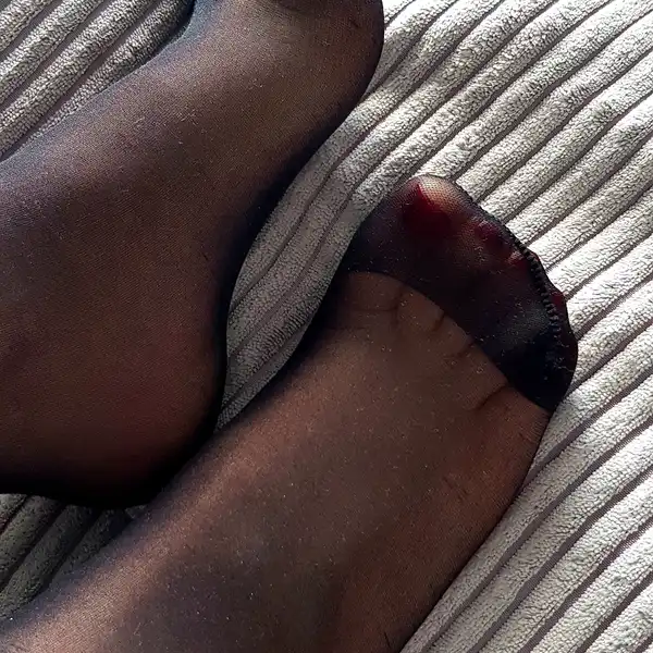 Cieniutkie, czarne i poszarpane rajstopy Bogini, noszone bez majtek i w szpilkach do kancelarii.